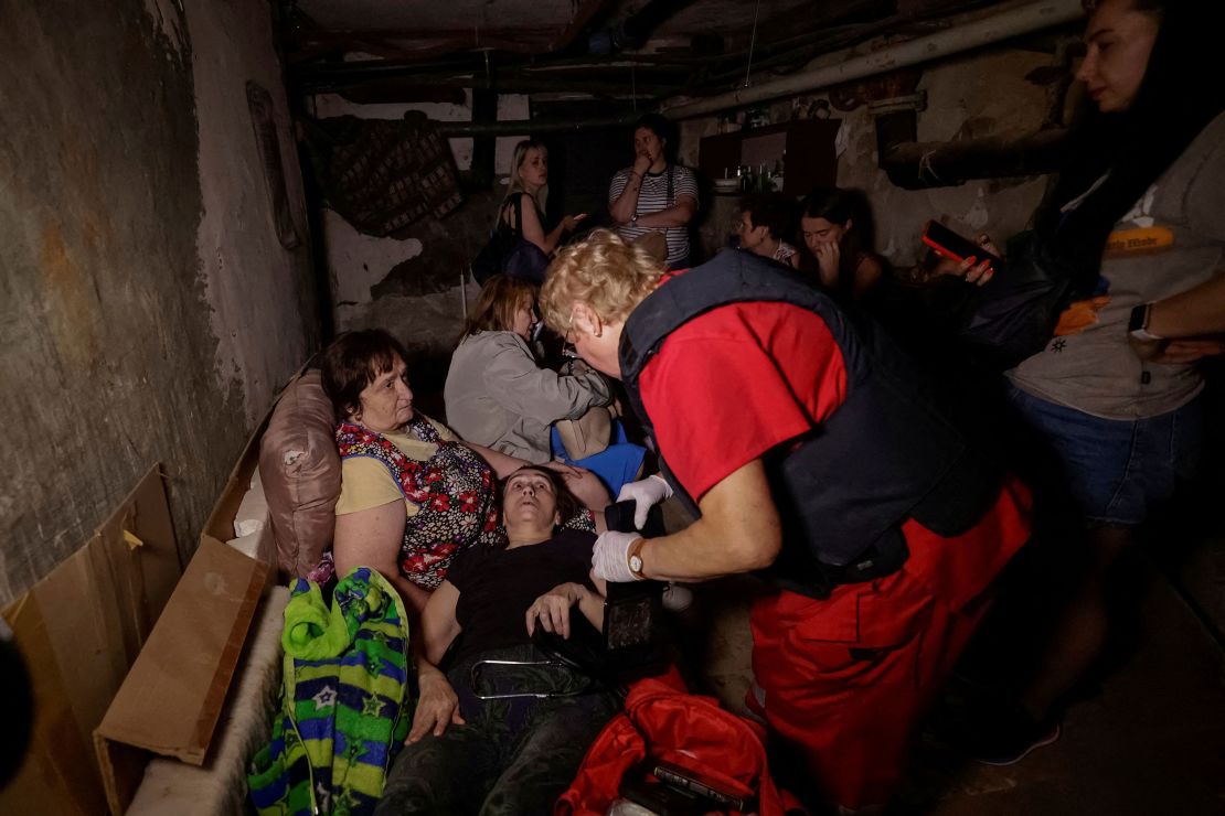 A medical worker treats a woman as people take shelter in the basement of their apartment building during a Russian drone strike in Kharkiv, Ukraine, on July 7.
